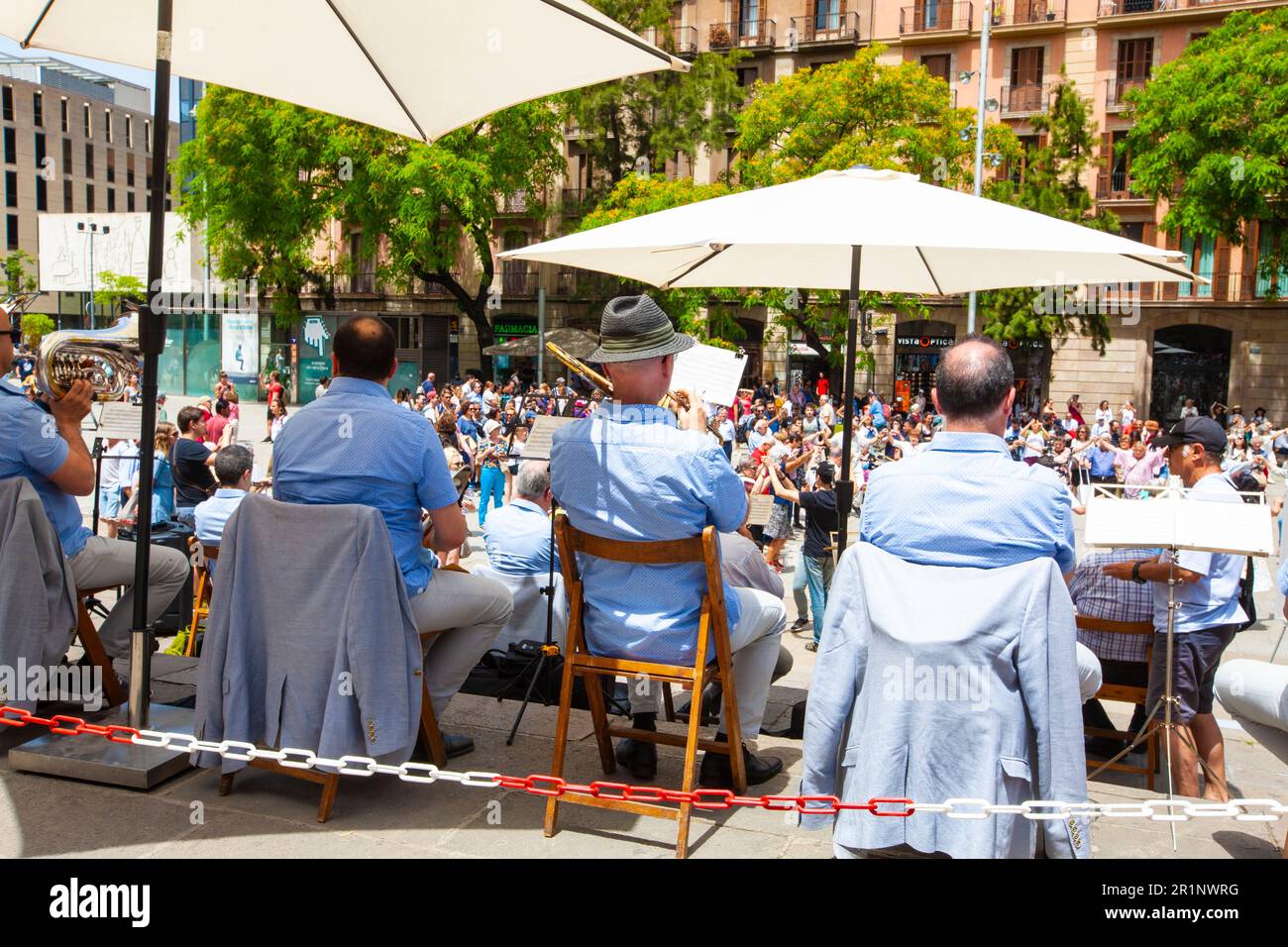 Senior people holding hands and dancing national dance Sardana at Plaza, Barcelona, Spain. It is a type of circle dance typical of Catalonia. Stock Photo