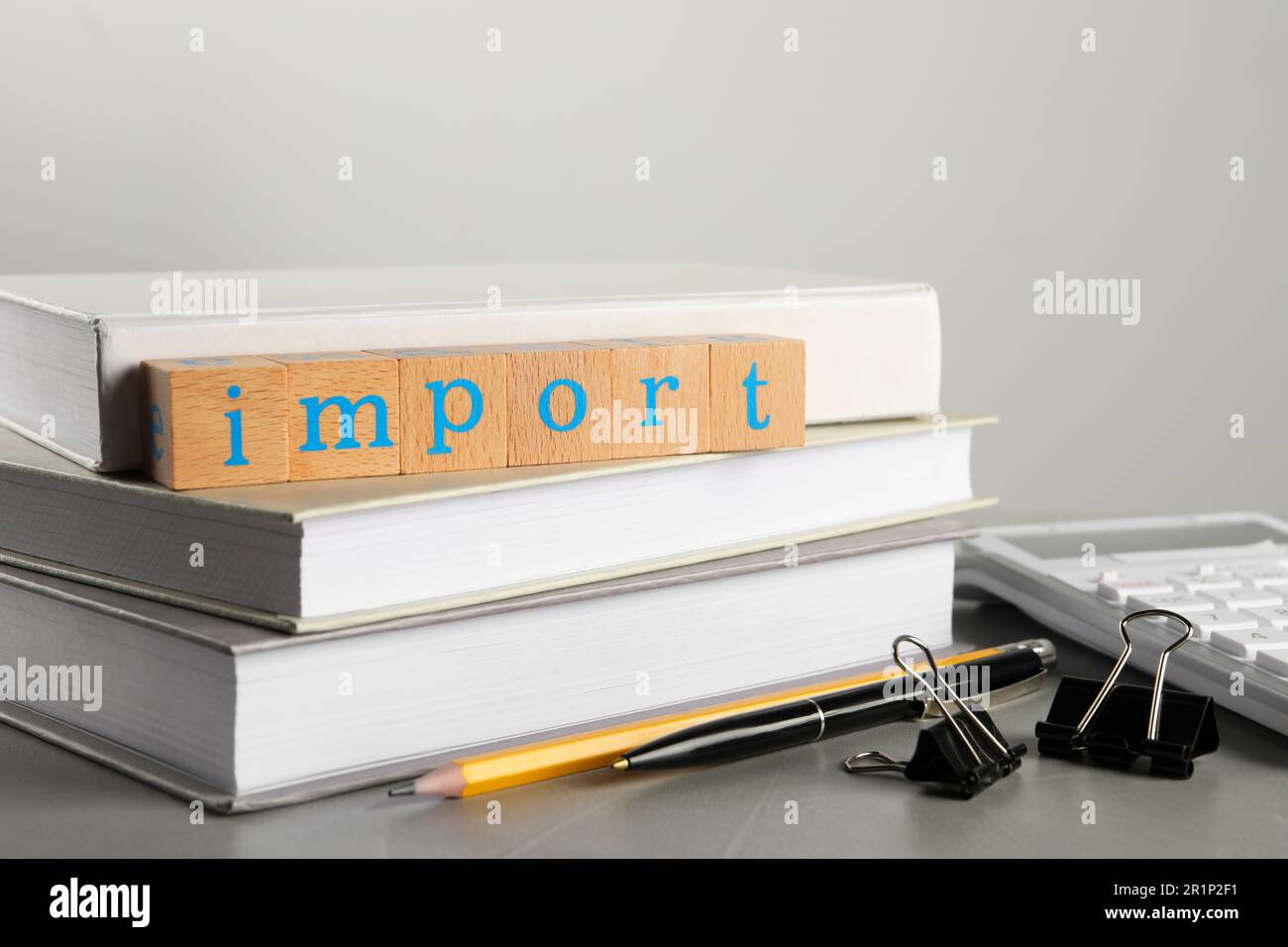 Word Import made of wooden cubes and office stationery on grey table, closeup Stock Photo