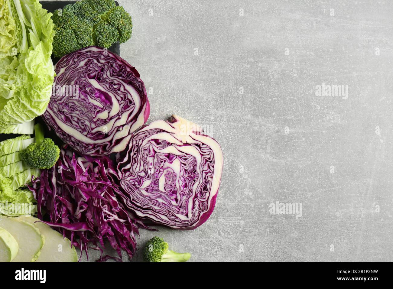 Different types of cut cabbage on light grey table, flat lay. Space for ...