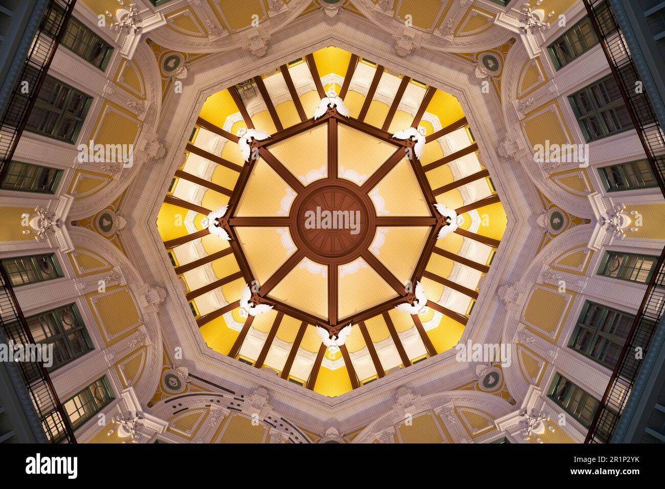 An interior shot of a domed structure, featuring large windows and yellow walls in the background Stock Photo