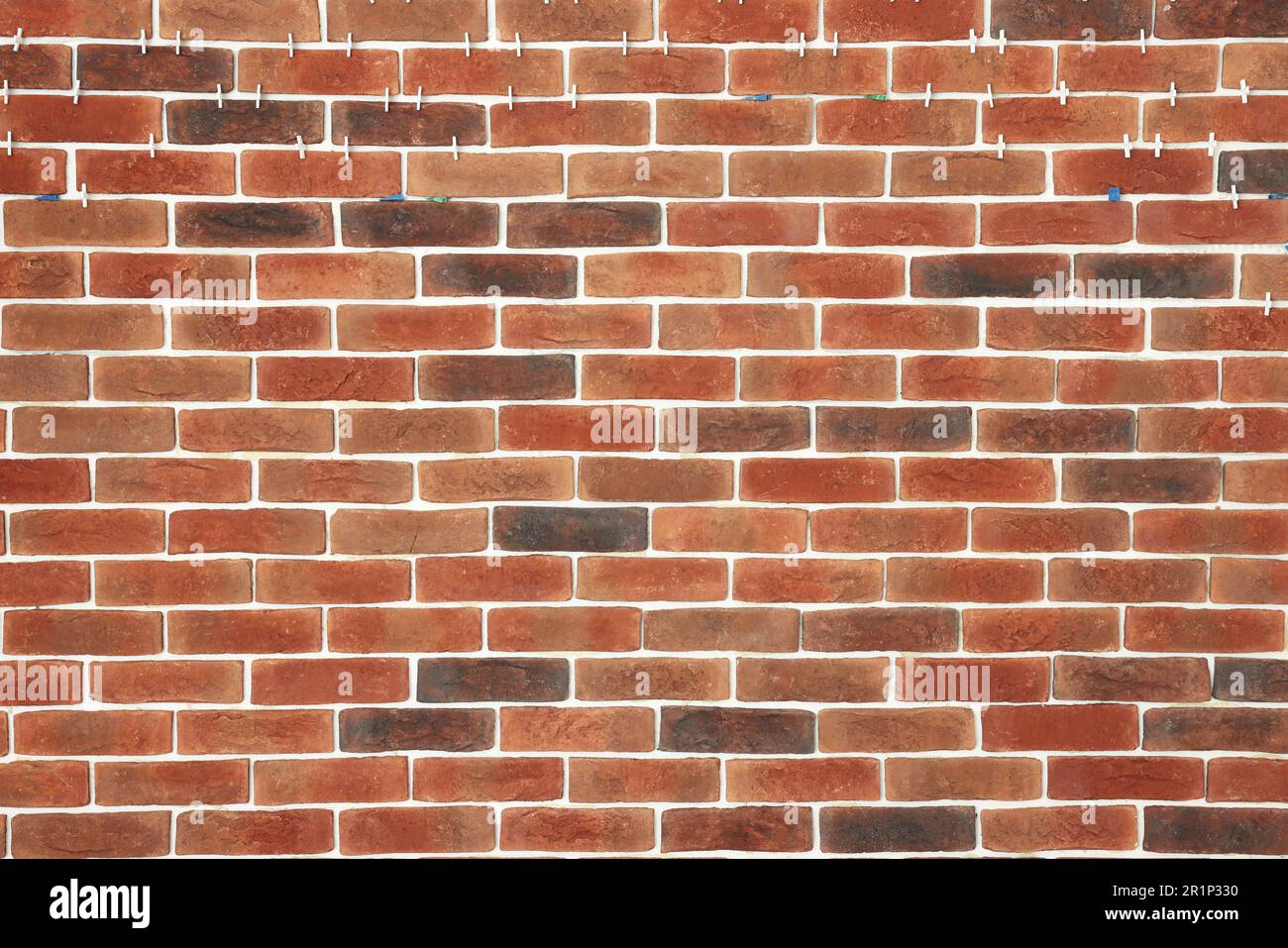 Decorative bricks with tile leveling system on wall Stock Photo