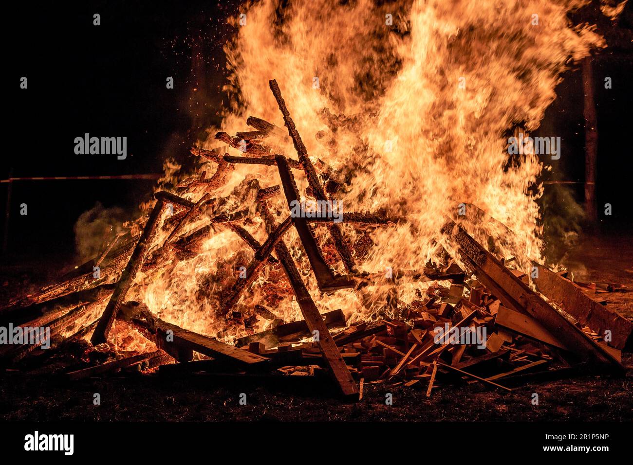 A blazing fire with bright orange flames set against a dark background Stock Photo