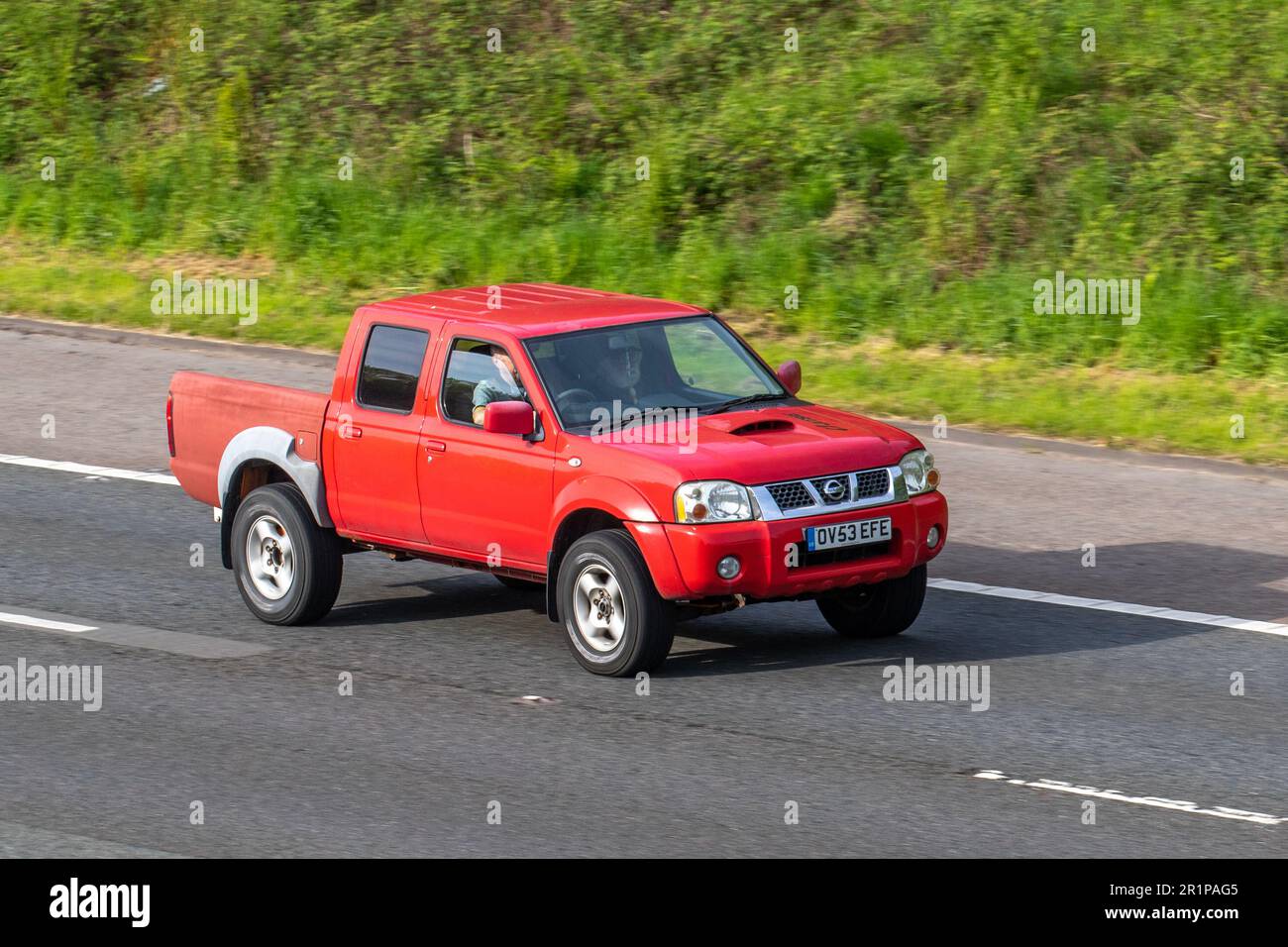 2004 Red Nissan Navara Rally Raid DT LCV Double Cab Pick Up Diesel 2488 cc; travelling on the M61 motorway, UK Stock Photo