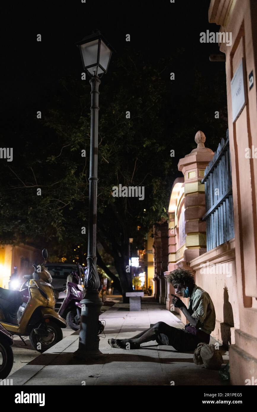 PUDUCHERRY, INDIA -FEBRUARY 7 2023: A person without a fixed abode is sitting on the street in the city. Stock Photo