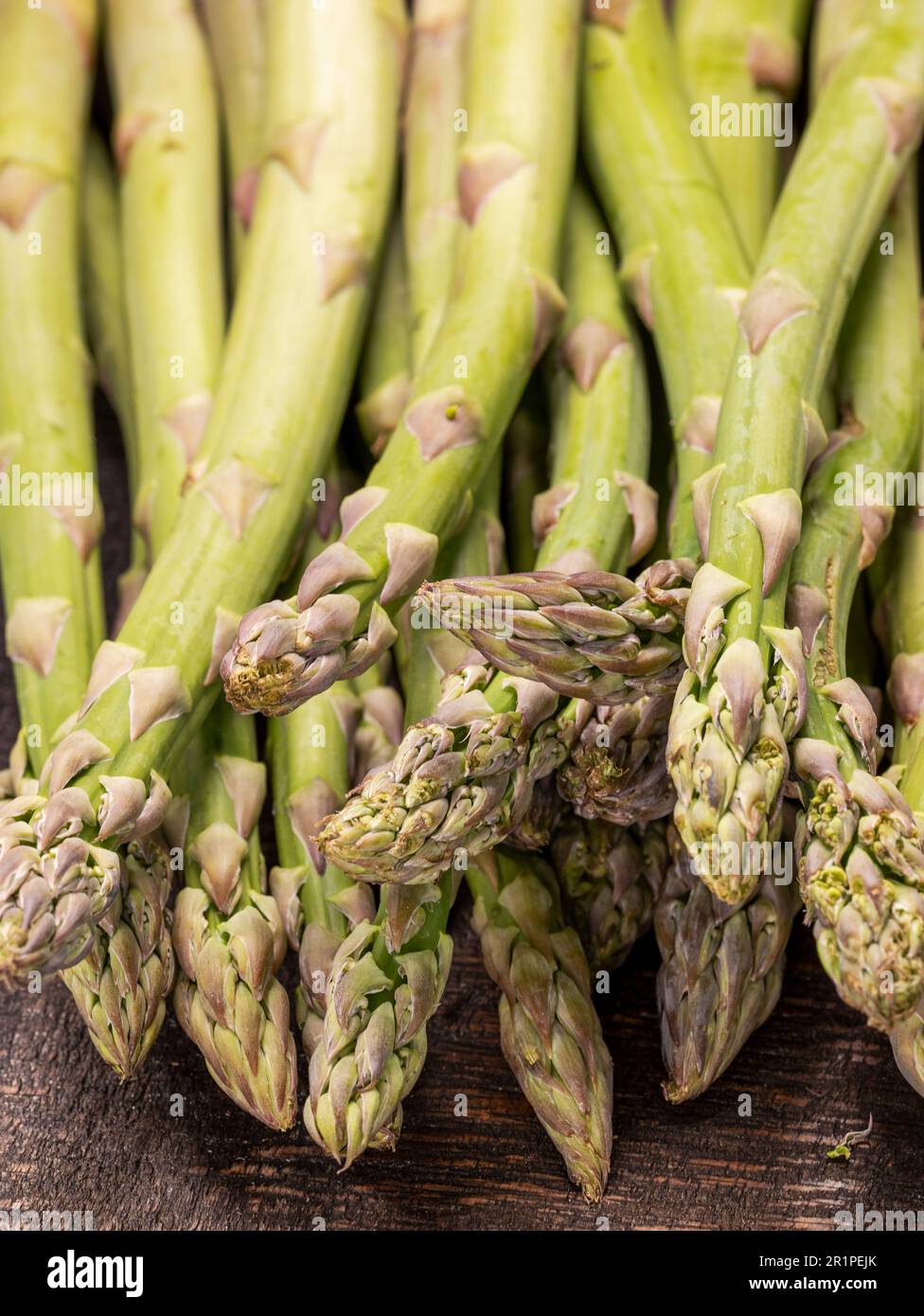Close up of fresh and raw green asparagus spears on old wooden board Stock Photo