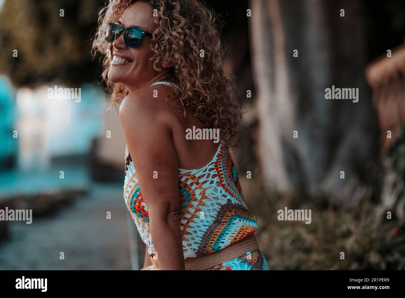 Carefree happy young mature woman smiling at the park. Outdoor joyful  leisure activity. Female adult people enjoying free lifestyle day. Healthy  curly hair lady with sunglasses. Attractive woman Stock Photo - Alamy