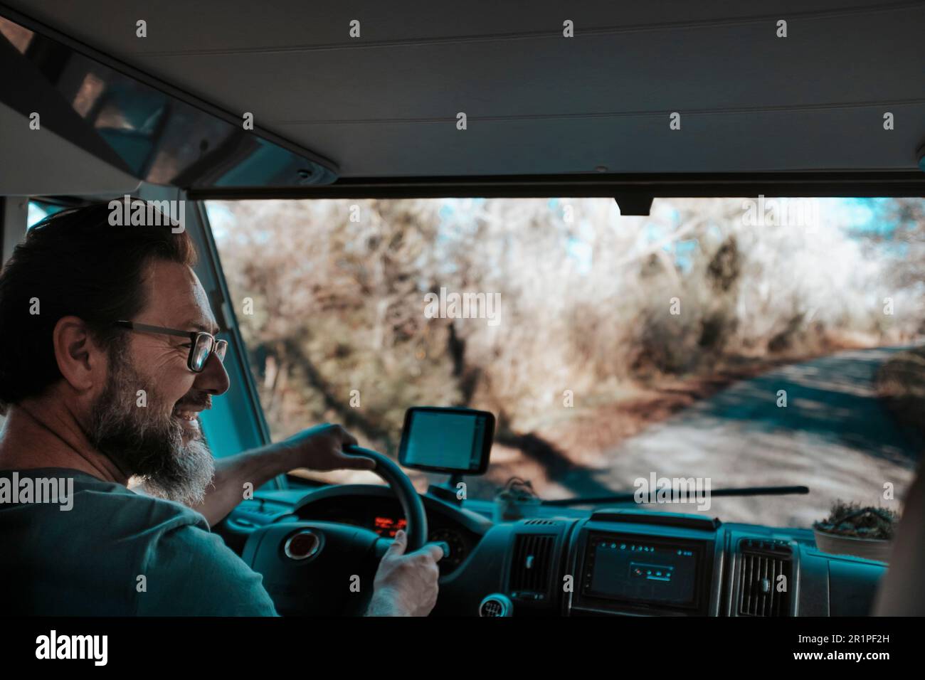 Happy man with beard smile and drive camper van, gps navigation system. Looking passenger and enjoying travel. Motor home caravan vacation holiday adventure concept lifestyle vanlife Stock Photo