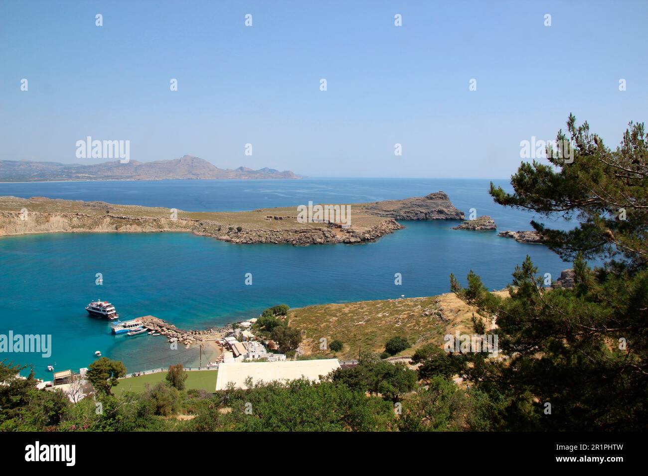 View from the Acropolis to the harbor, Lindos Bay, sea, seashore, Lindos, Rhodes, Dodecanese, Greece, grasses, atmospheric, blue sky Stock Photo
