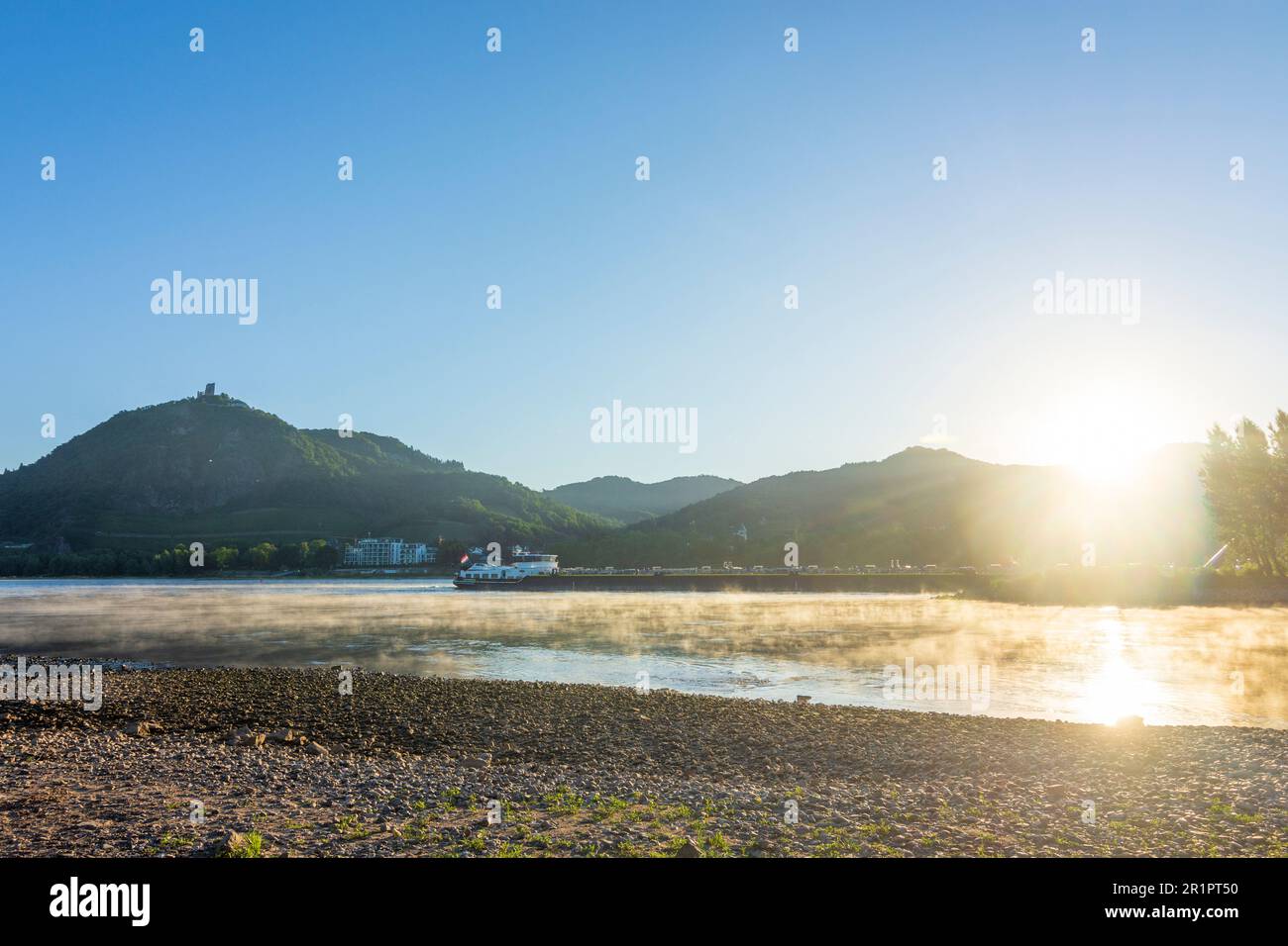 Königswinter, hill Drachenfels in mountain Siebengebirge with Schloss Drachenburg (left) and Drachenfels Castle (right), river Rhein (Rhine), cargo ship, sunrise in Rhein-Sieg-Region, North Rhine-Westphalia, Germany Stock Photo