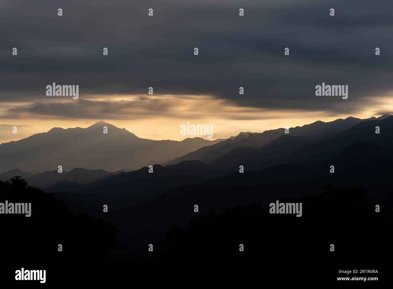 Layers of Mountains at Sunset with Silhouette and Dramatic Clouds Stock ...