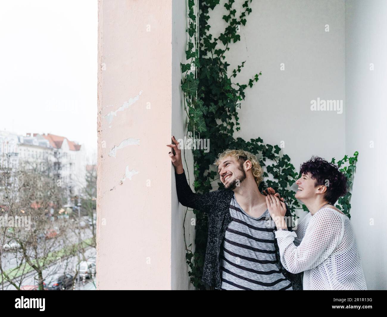 Non-binary couple on balcony Stock Photo - Alamy