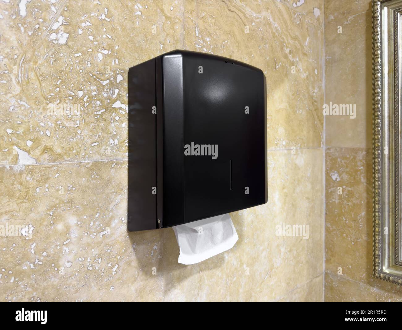 New paper towel dispenser hanging on wall near mirror in bathroom ...