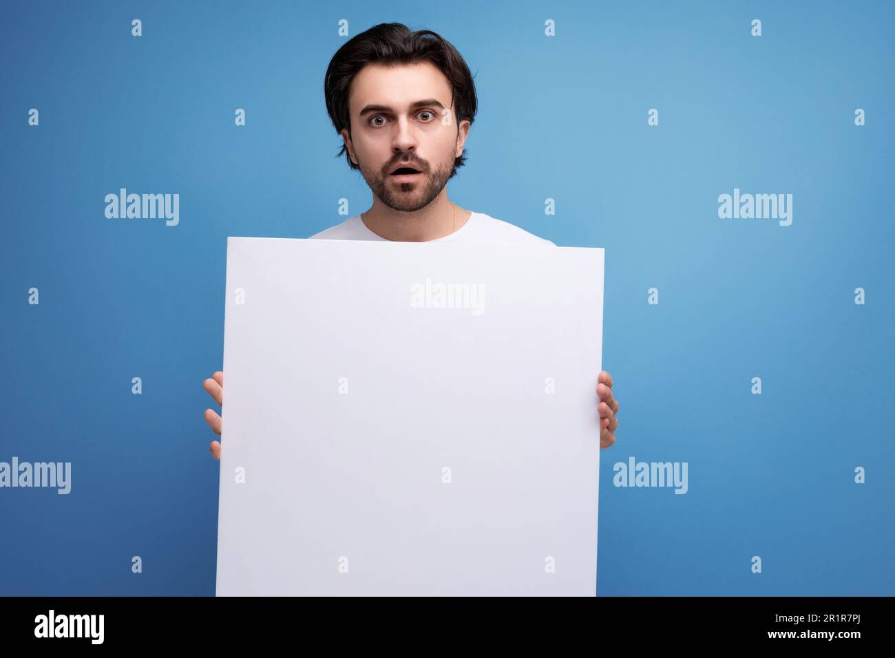 young brutal brunette guy with poster mockup Stock Photo
