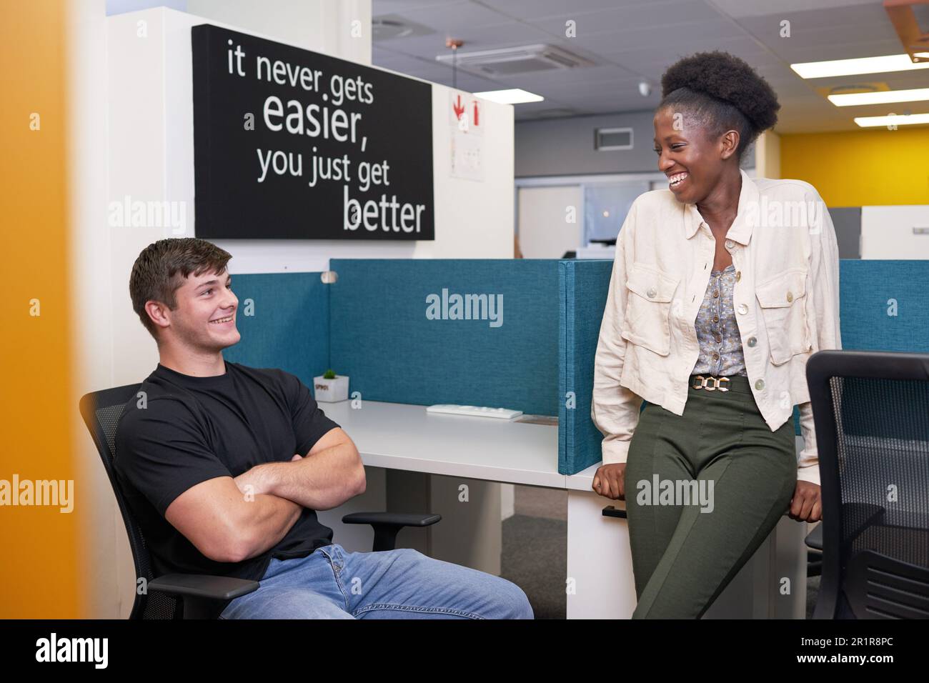 Two young college students relax in the library, talking and chatting Stock Photo