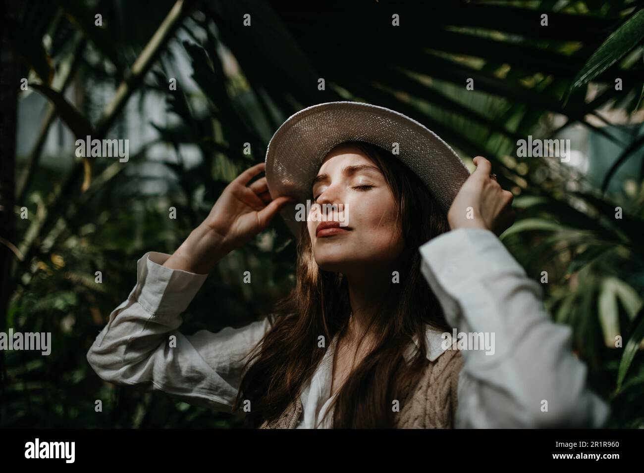 Portrait of young woman in botanical garden. Stock Photo