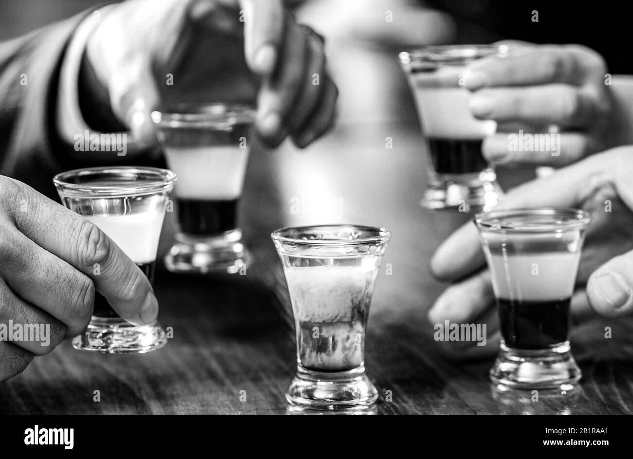 https://c8.alamy.com/comp/2R1RAA1/friends-drink-shot-or-liqueur-five-glasses-of-alcoholtequila-shots-vodka-whisky-rum-black-and-white-2R1RAA1.jpg