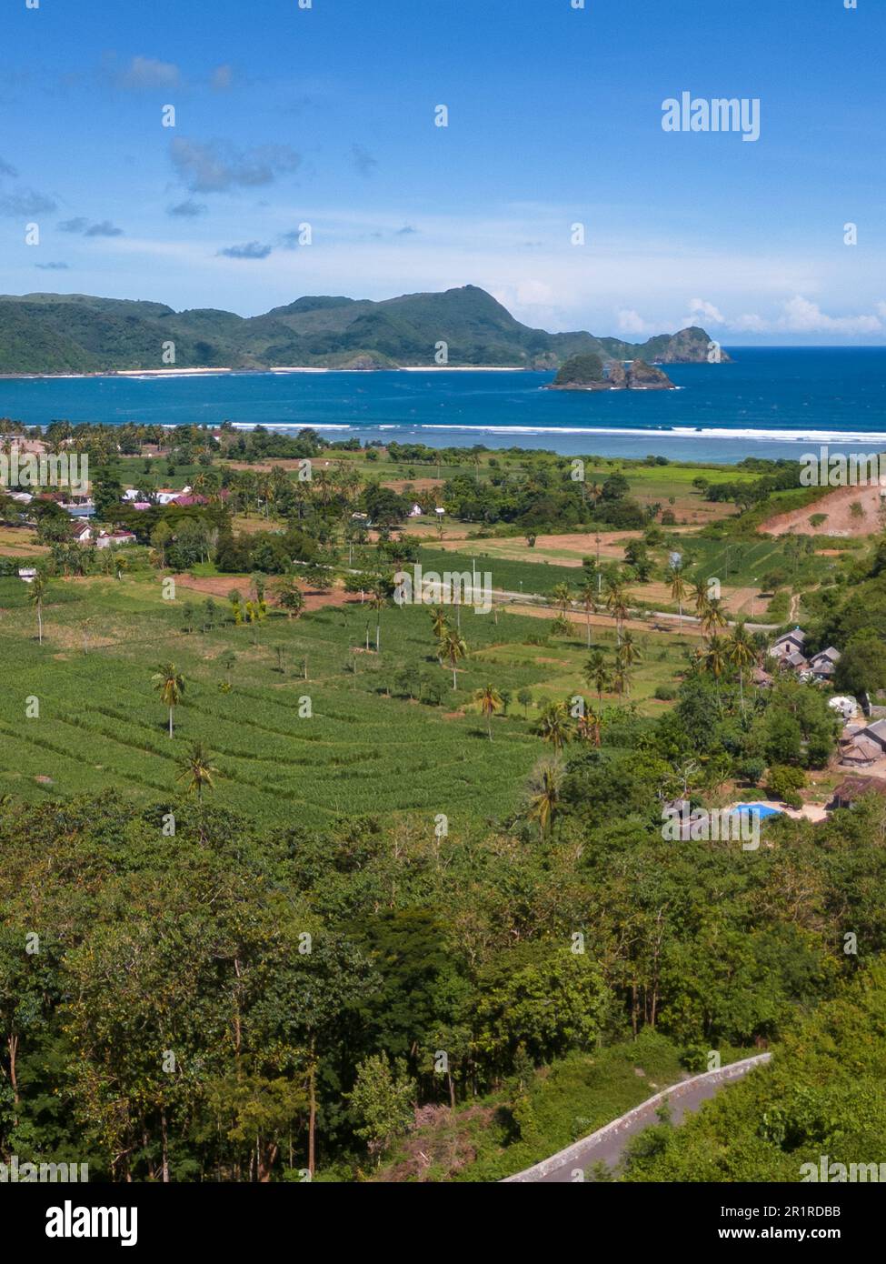Lush rural landscape with Selong belanak beach in distance, Lombok, Indonesia Stock Photo