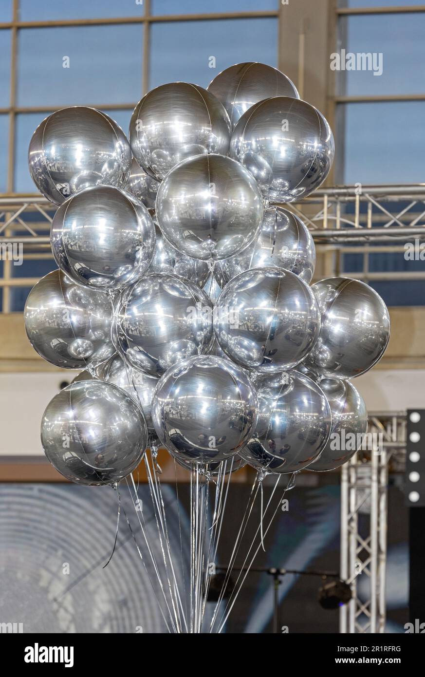 Cluster of Helium Filled Metallic Foil Silver Balloons in Hall Stock Photo