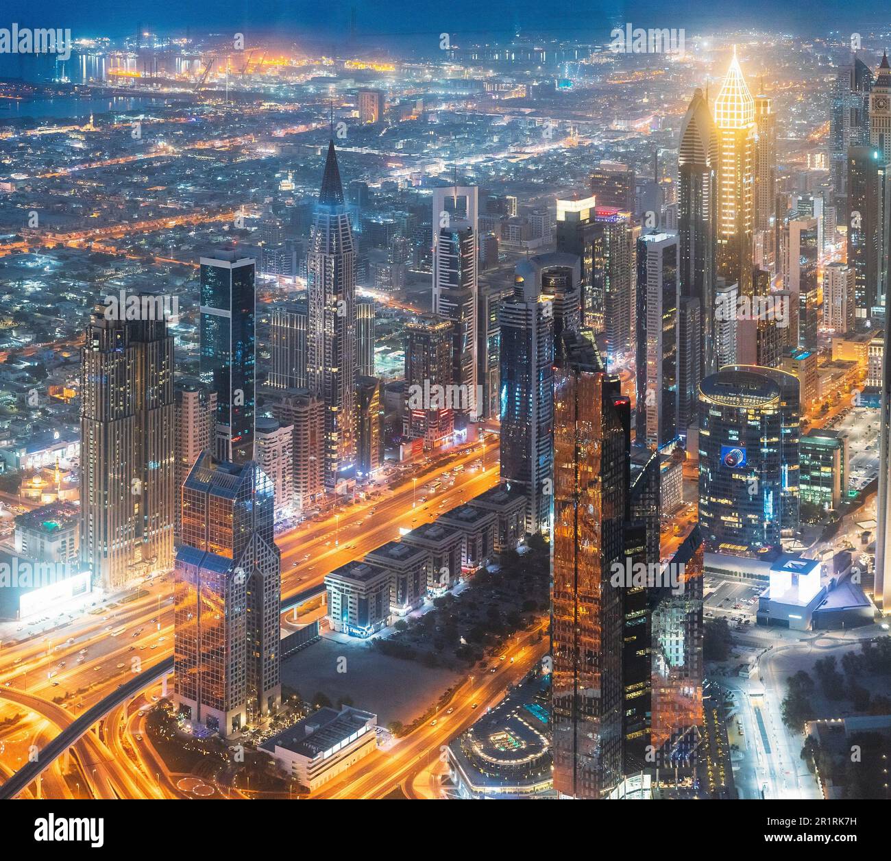 Aerial View Of Urban Background Of Illuminated Cityscape With Skyscrapers In Dubai. Street Night Traffic In Dudai Skyline. Moving through modern city Stock Photo