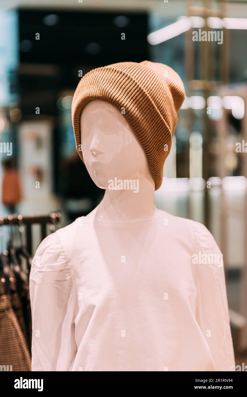 Casual warm Hat On Mannequin In Store Of Shopping Center. shelf display in shop mall store. Store Of Shopping Center. retail sale. Stock Photo