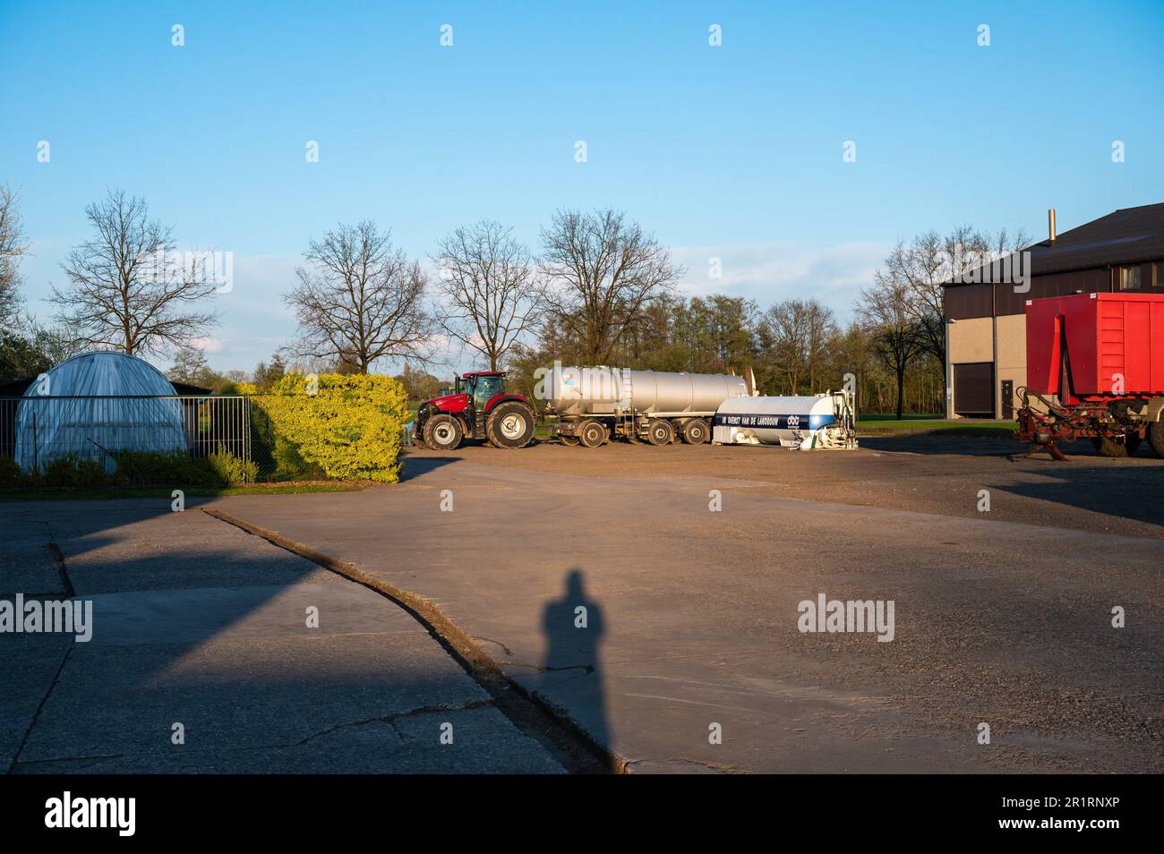Meerhout, Antwerp Province, Belgium - April 25, 2023 - The main court of a modern farm with barns and agriculture vehicles. Stock Photo
