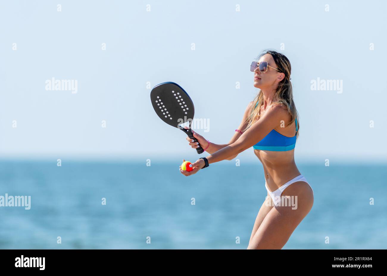 Woman playing beach tennis on a beach. Professional sport concept. Horizontal sport theme poster, greeting cards, headers, website and app Stock Photo
