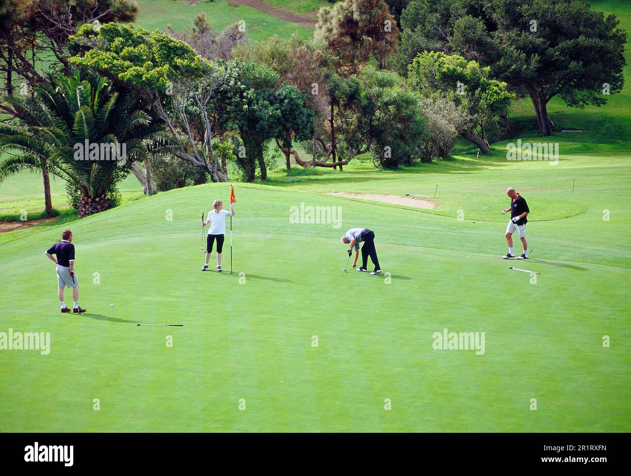 Four people playing golf. Caldera de Bandama Golf Club, Gran Canaria island, Canary Islands, Spain. Stock Photo