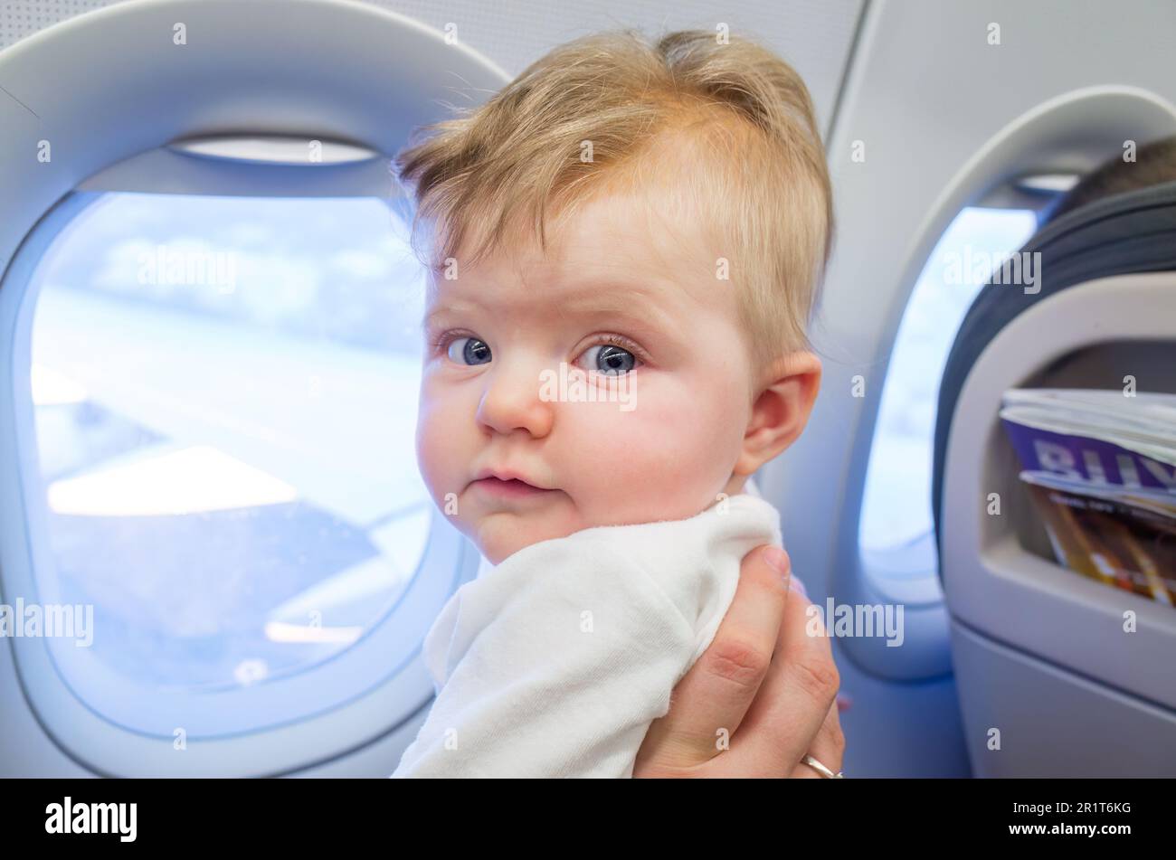 Mother travelling on an aeroplane with a six month old baby girl Stock Photo