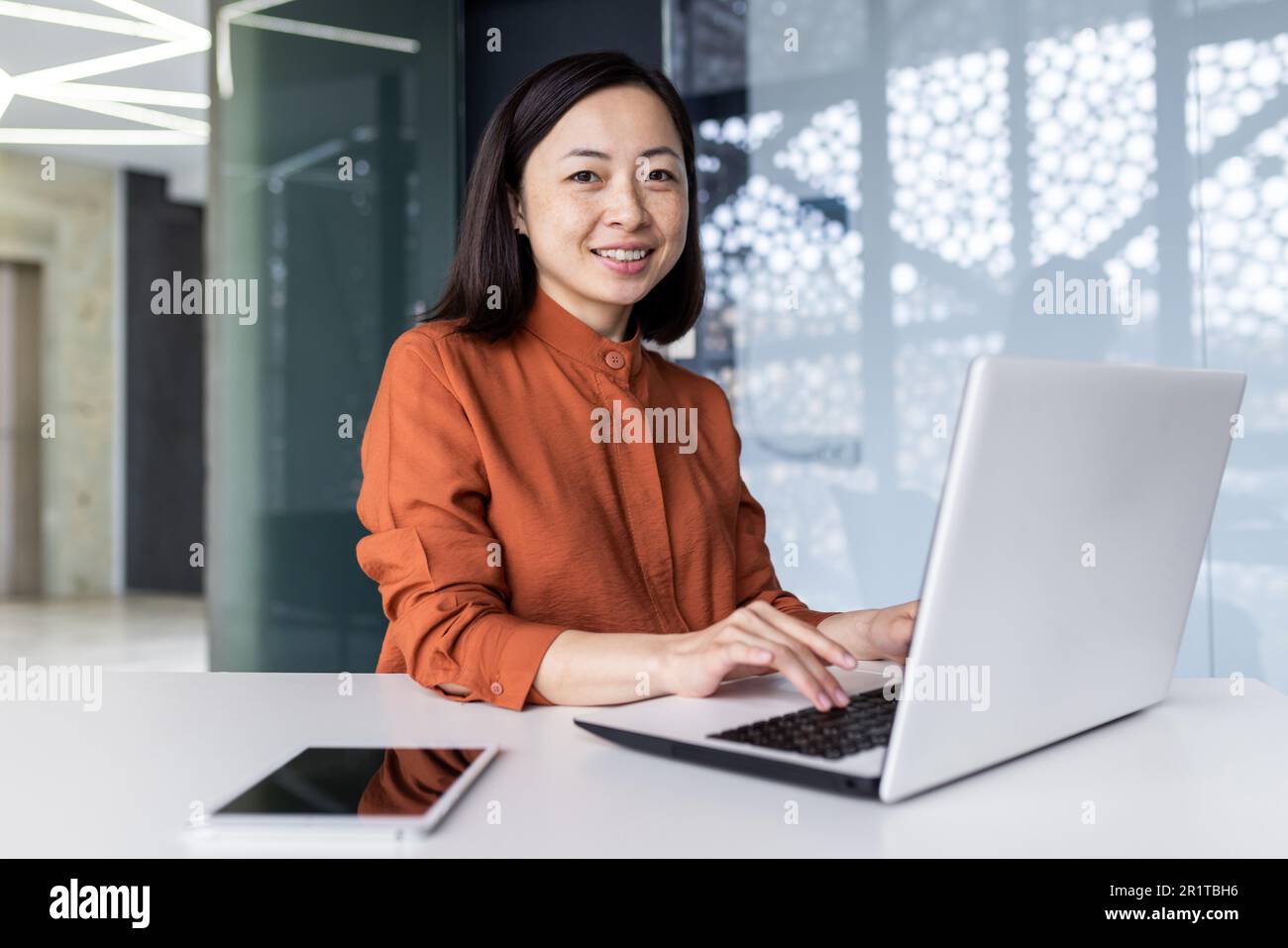 Portrait of a young Asian business woman working in the office at the ...
