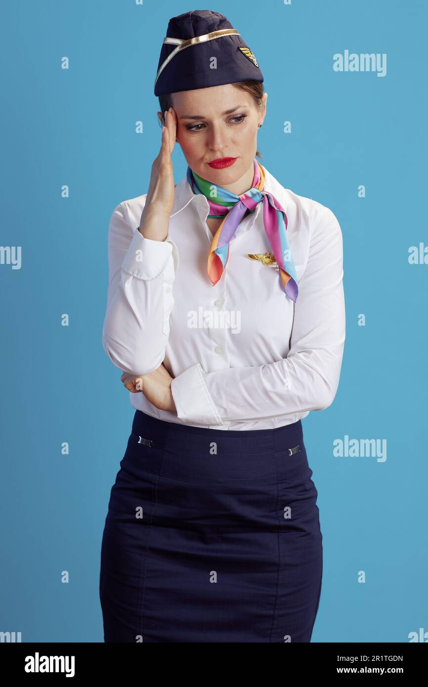 stressed modern flight attendant woman on blue background in uniform