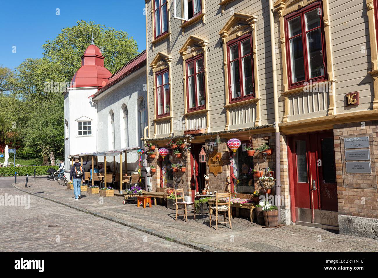 Cafe, restaurant in traditional wooden building in Allmanna vagen with Matteus Kyrkan (church) in Majorna in background. Gothenburg. Stock Photo