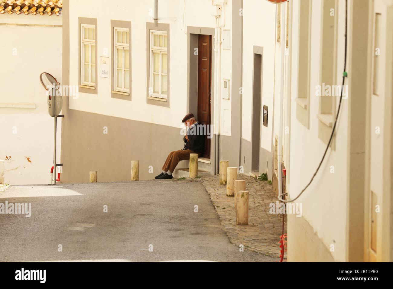 Old man sitting on a doorstep, Old Town, Lagos, Algarve, Portugal Stock Photo