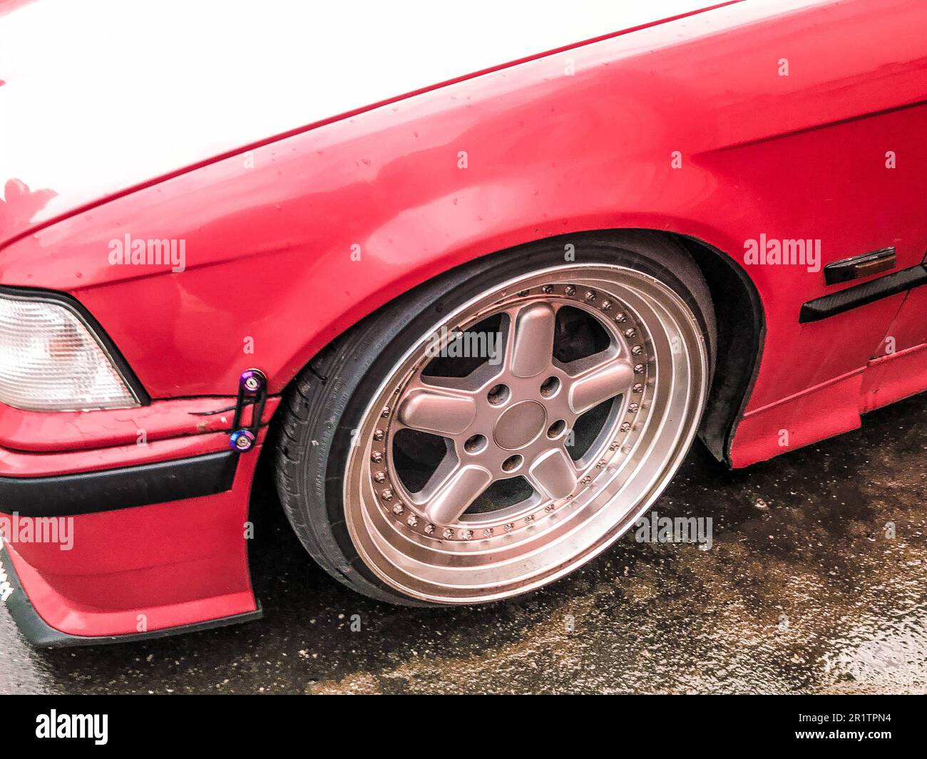 Beautiful big racing wheels of a sports red car with a very low ground