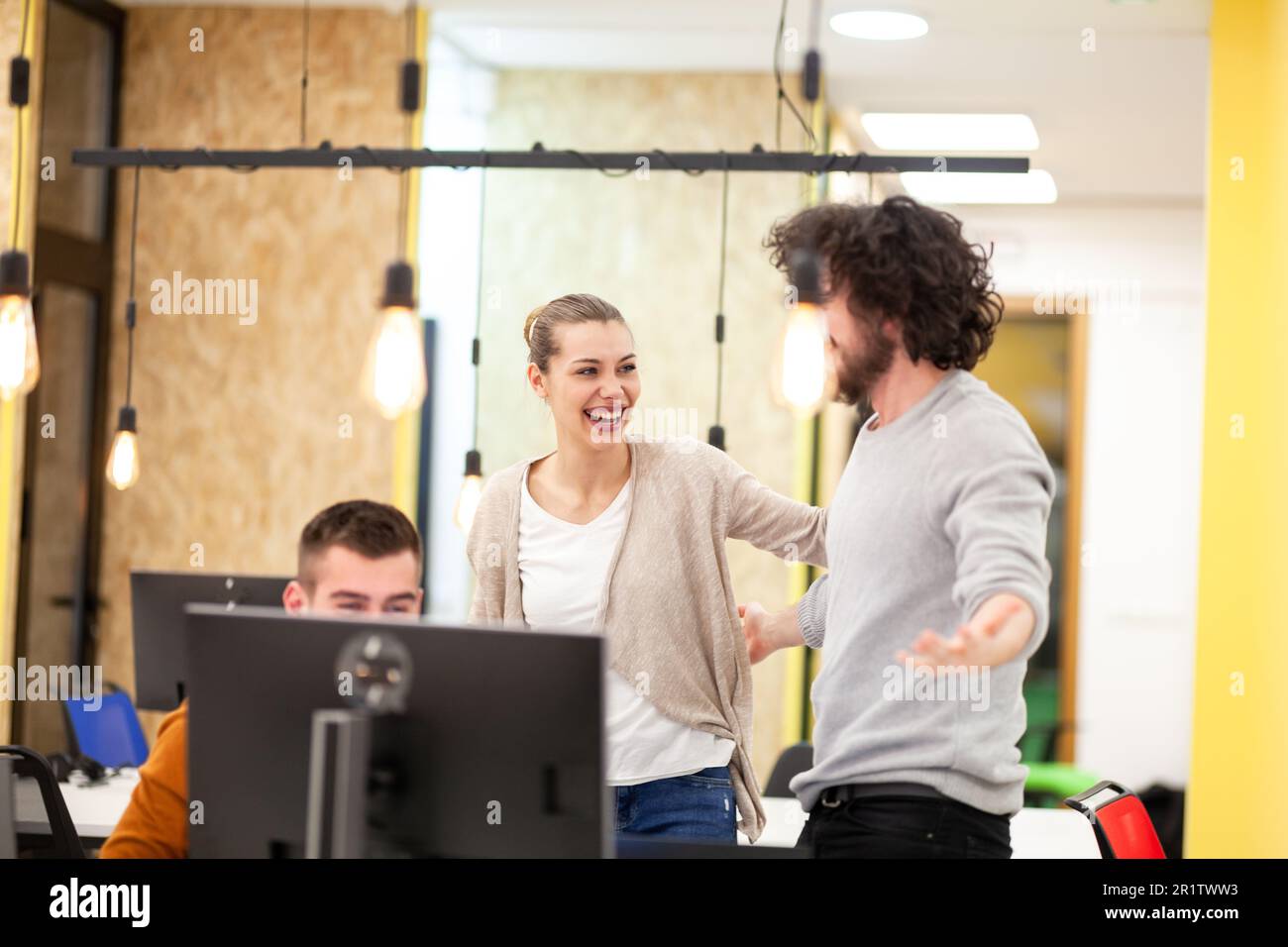 Three caucasian colleagues cheering for job well done in a modern
