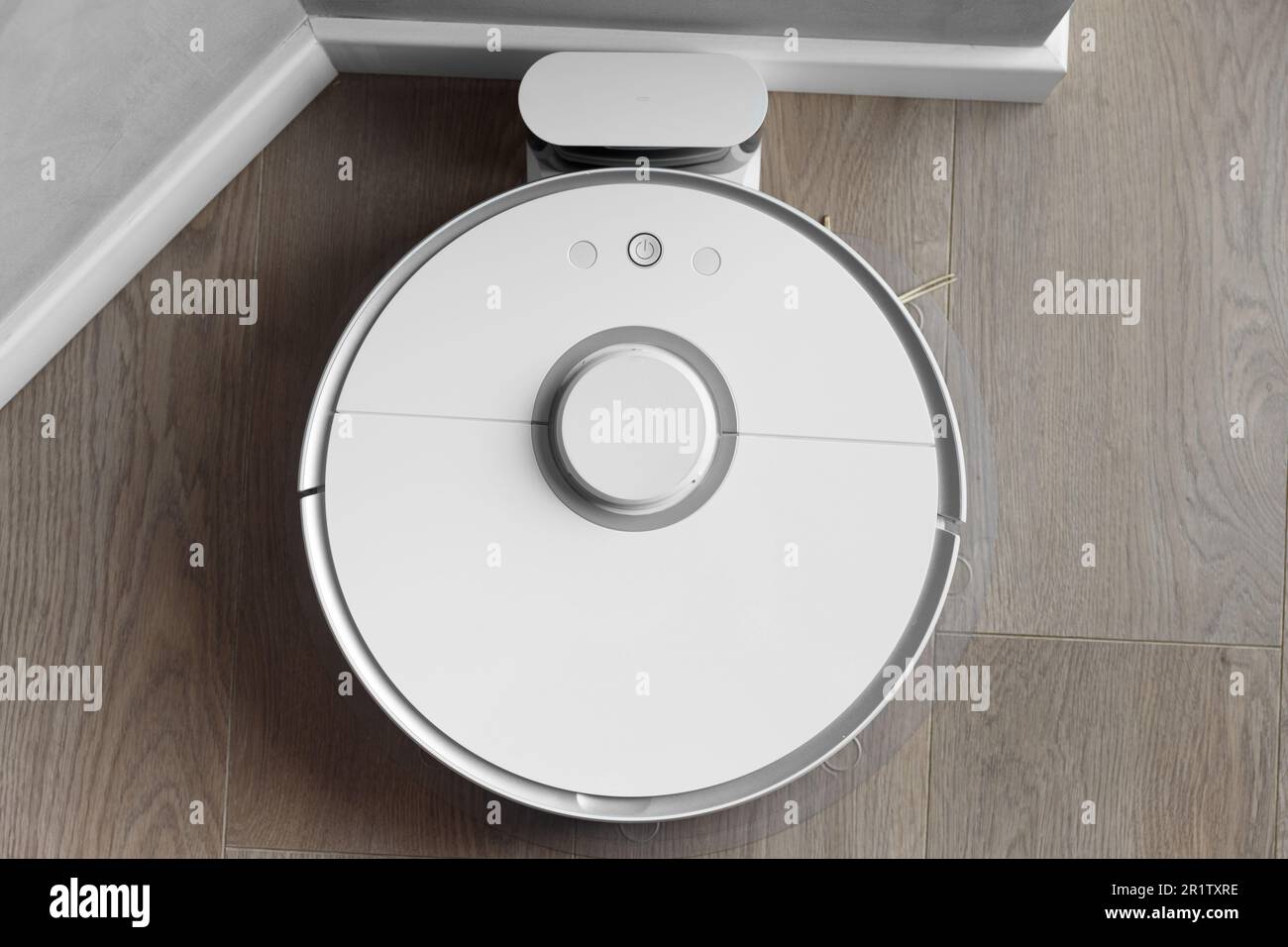 White robot vacuum cleaner is charging on the docking station, smart cleaning, smart automatic