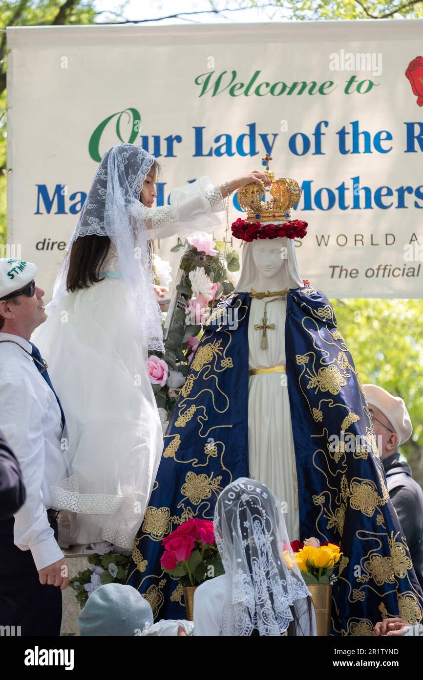 An 8 year old Hispanic girl from Corona performs the Roman Catholic ceremony of May Crowning. In Flushing Meadows Corona Park in Queens, NYC. Stock Photo