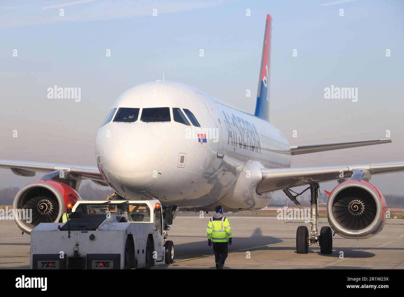 A commercial airliner serviced at a major airport in the late afternoon Stock Photo