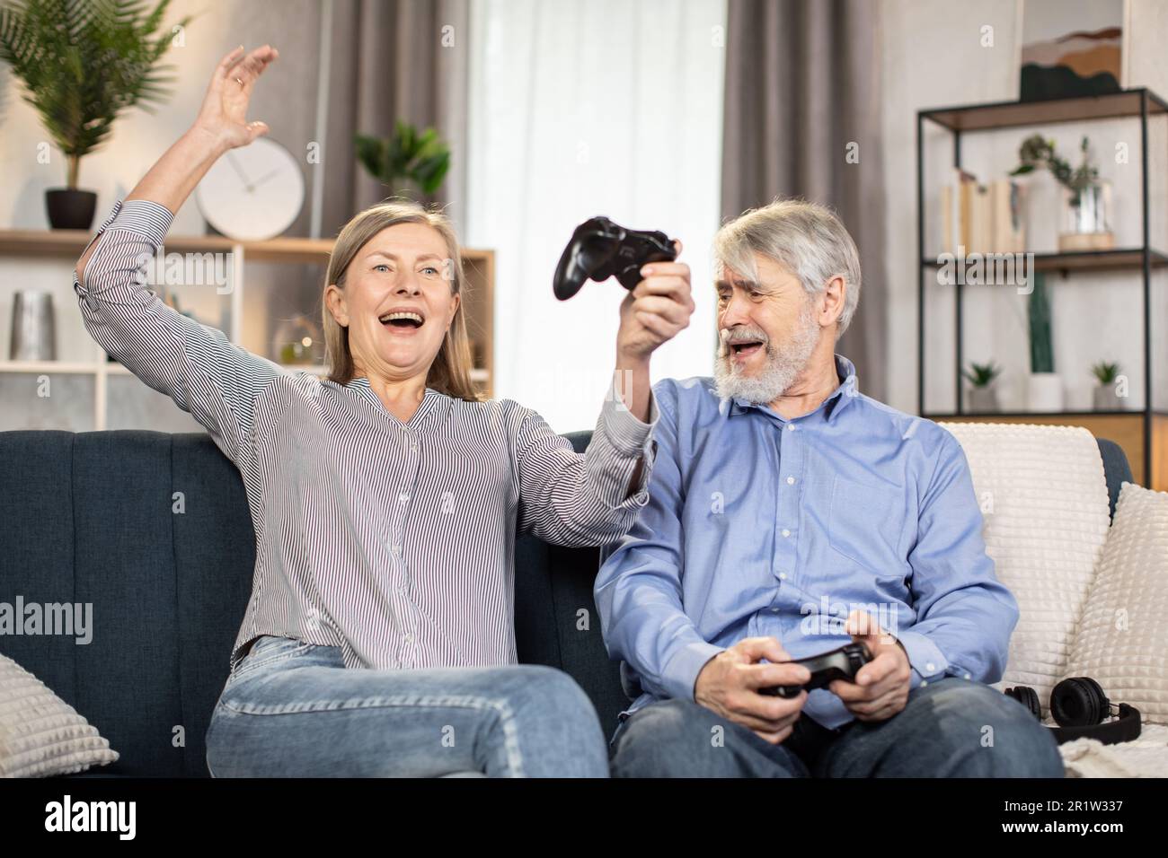 Mindful couple of senior people sitting on sofa with black input