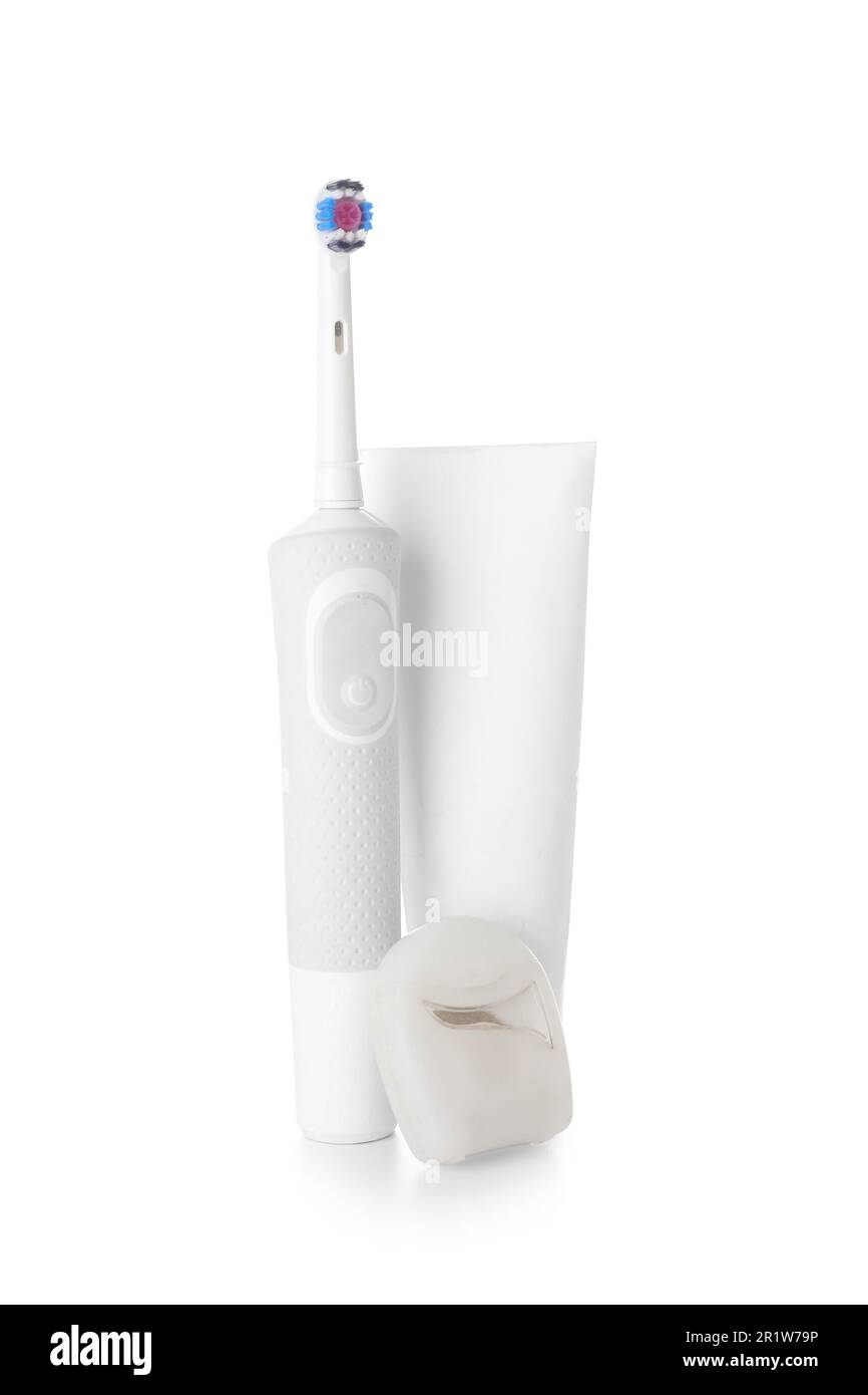Electric toothbrush with paste and dental floss on white background ...