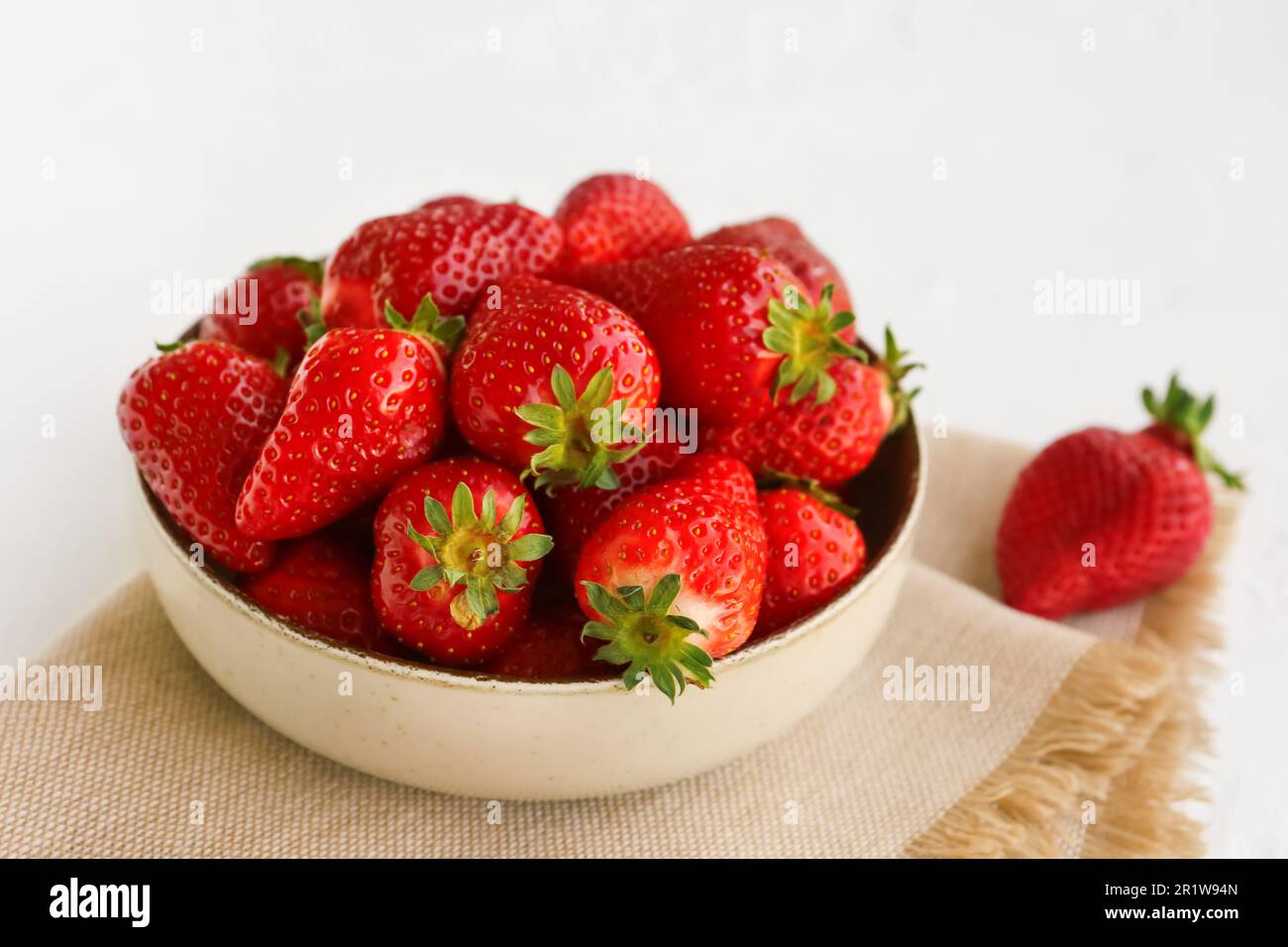 Bowl with fresh strawberries on white background Stock Photo - Alamy