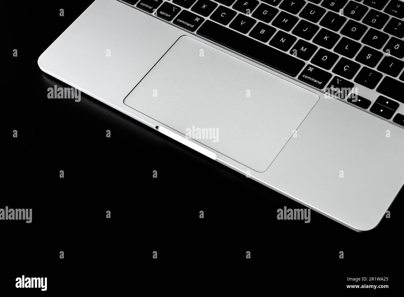 Keyboard and trackpad, grey keyboard on black background Stock Photo