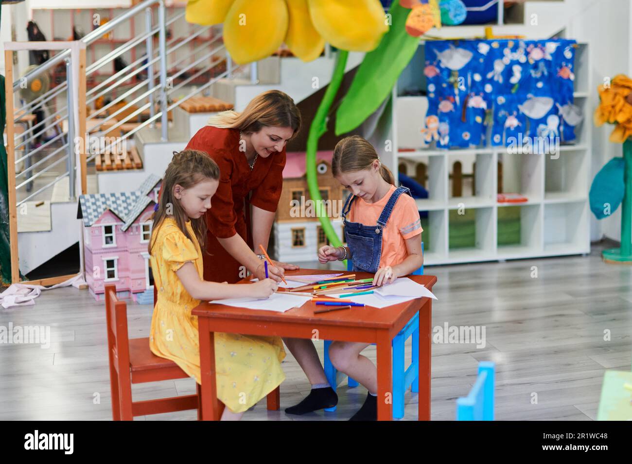Creative kids during an art class in a daycare center or elementary school classroom drawing