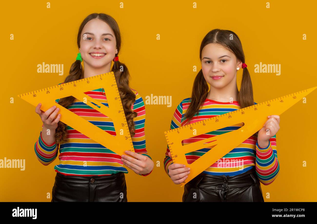 happy school children hold math tool of triangle Stock Photo - Alamy