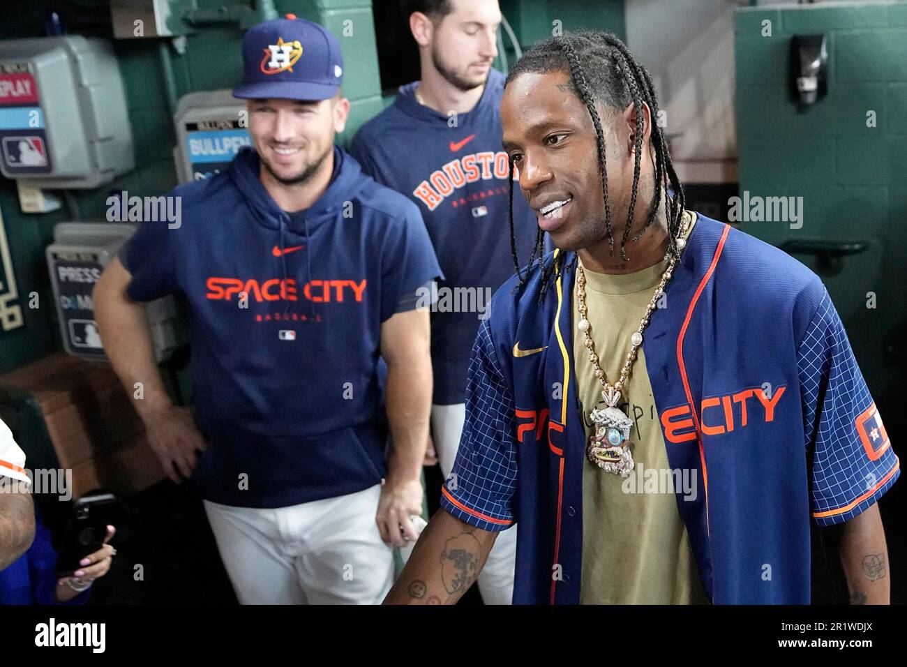 Houston rapper Travis Scott, right, is joined by Houston Astros Alex  Bergman, left, and Kyle Tucker, as he waits to hit before a baseball game  between the Chicago Cubs and Houston Astros