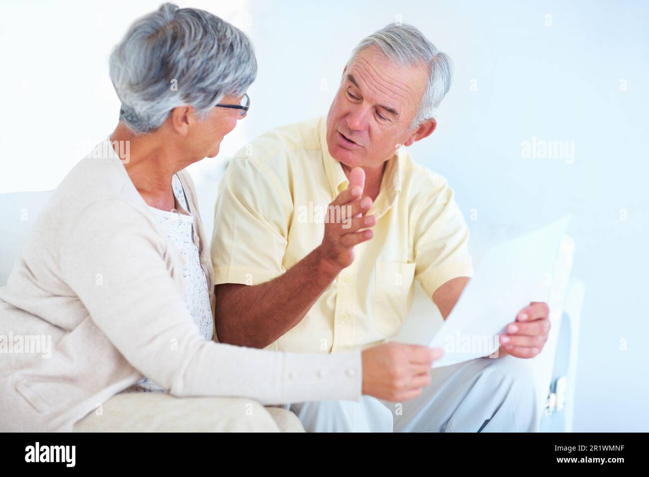Mature couple during discussion. Happy mature couple discussing while reading letter at home. Stock Photo