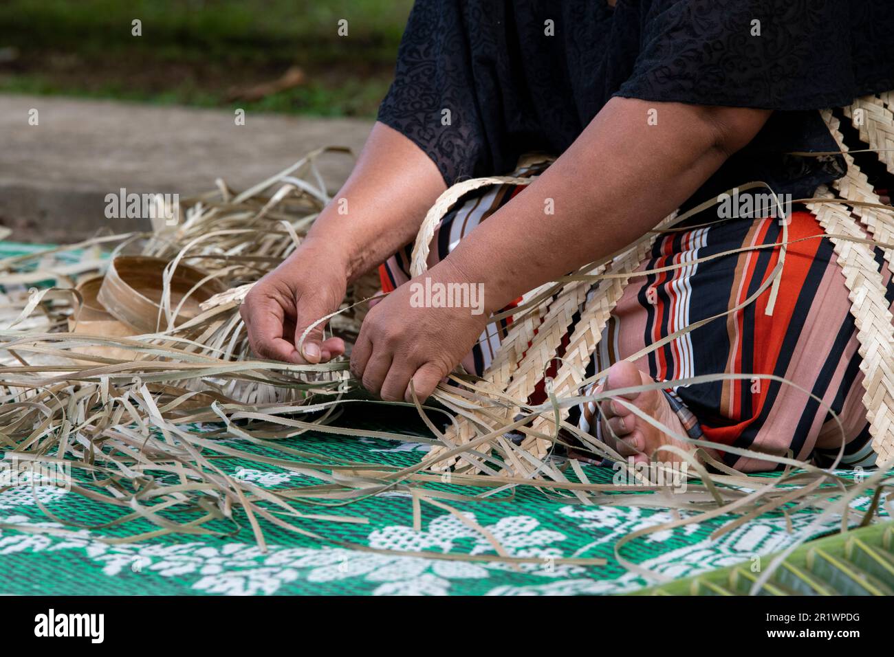 Kingdom of Tonga, Neiafu. Local woman weaving straw mat. Stock Photo