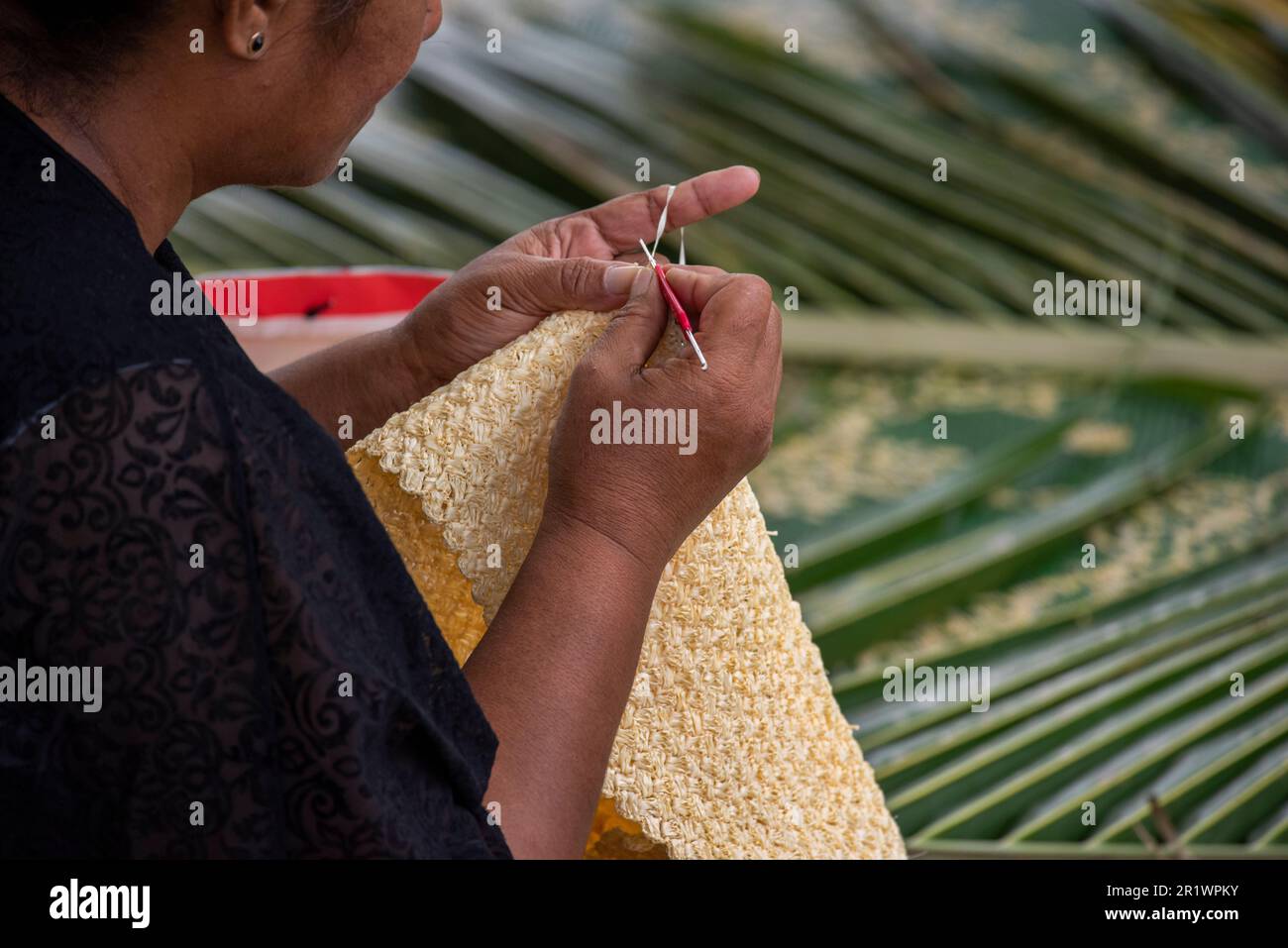 Kingdom of Tonga, Neiafu. Local woman crocheting straw. Stock Photo