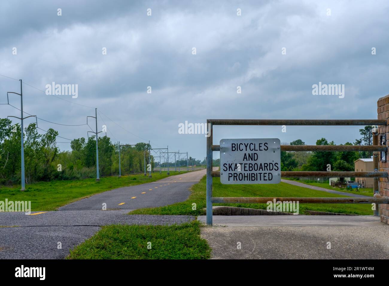 NEW ORLEANS, LA, USA - MARCH 31, 2023: 'Bicycles and Skateboards Prohibited' sign on a gate on the Mississippi River levee in Kenner, LA, USA Stock Photo