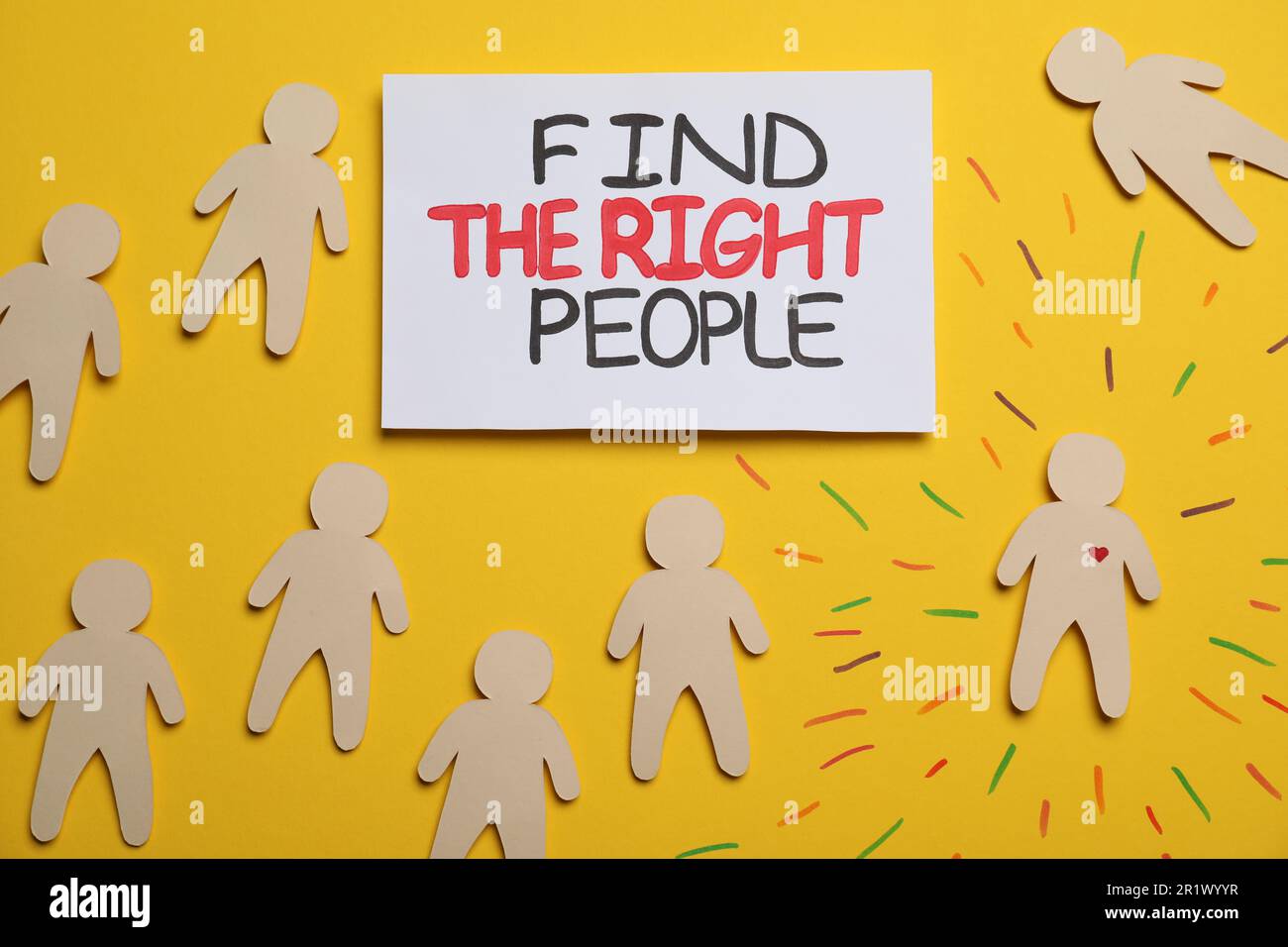 Find the right people. Human paper figure with drawn heart among others without it on yellow background, flat lay Stock Photo