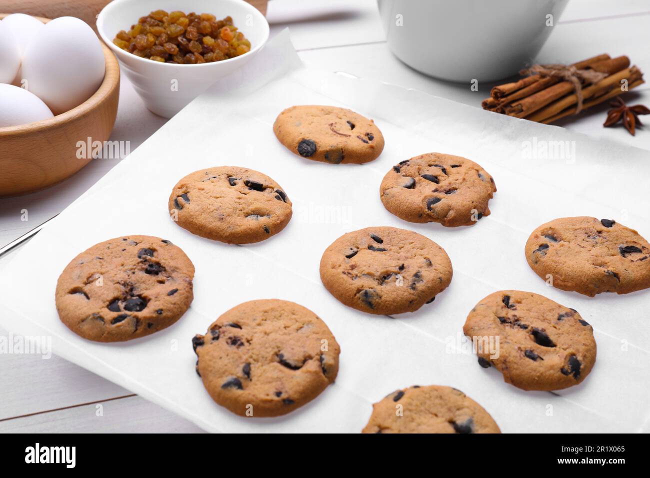 Parchment baking paper with tasty cookies on white table, closeup Stock Photo